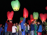 Участники фестиваля запускают в ночное небо разноцветные китайские фонарики